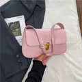 Roze minimalistische kunstlederen schoudertas met gouden draaislot en verstelbare riem - Roze