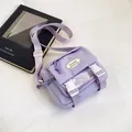 Large lavender nylon crossbody bag with dual white buckles and fashion label - Purple