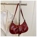 Détail du sac sous le bras en cuir verni rouge foncé avec boucle argentée en demi-lune - Rouge