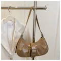 Détail du sac hobo en cuir verni kaki avec design plissé et grande boucle métallique - Kaki