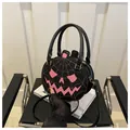 Detail of pumpkin-shaped crossbody bag with pink spider web and carved face design - Black Pink