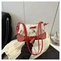Detail mit rotem Karomuster, Spitzenrüschen und Herzanhänger an der kleinen Schultertasche - Rot
