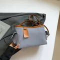 Schicke hellblaue Textil-Schultertasche mit braunem Lederbesatz und praktischen Seitentaschen - Blau