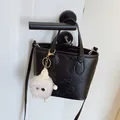 Elegant black embossed crossbody bucket bag with cartoon character and plush pendant - With Charm / Black