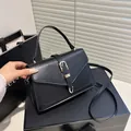 Chic black matte leather crossbody square bag with a golden U-shaped buckle and top handle - Black