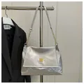 Detail of silver handbag featuring snakeskin texture and golden square metal buckle hardware - Silver
