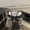 Zwart-witte schoudertas met stippen, strik en een zilverkleurige hartvormige hanger - Zwart