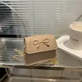 Mini beige crossbody bag with gold bow clasp and metallic chain strap for women - Khaki