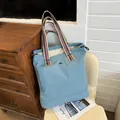 Grote blauwe canvas shopper met kleurrijke gestreepte handvatten en trekkoordsluiting - Blauw