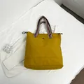 Mustard yellow canvas tote bag with colorful striped handles and drawstring detail - Dark Yellow