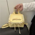Minimalistischer hellgelber Mini-Rucksack aus Kunstleder mit Schleife und Spitze - Gelb
