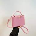 Roze crossbodytas met litchi-textuur, handvat en gouden metalen V-vormig logo - Roze