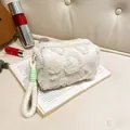 Pochette trucchi in peluche bianca con cuore su un libro per viaggio e bellezza - Bianco
