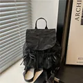 Black crinkle textured backpack with side bows and Nika logo on the flap closure - Black