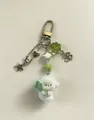 Macro detail van pluche puppy sleutelhanger met klavertje vier en metalen bedeltjes - Sleutelhanger stijl