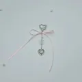 Detalle de lazo de seda rosa y colgante de cuentas de corazón para móvil - Cierre de Bolso de Corazón con Lazo
