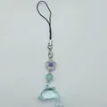 Nahaufnahme von lichtdurchlässigem Delfin-Anhänger aus Harz mit lila Blume und Perle - Violettblau