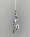 Close-up of cute fish pendant and star bead on a white minimalist braided strap - Phone Chain / Abundance Theme