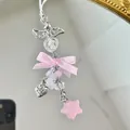 Close-up of pink satin bow, angel wing, pearl heart, and star charm for phone or bag - Pink Bow Style