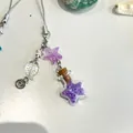 Detalle de amuleto de estrella de mar y botella de vidrio estrellada con cuentas violetas - Púrpura
