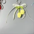 Detalle de colgantes de tulipanes amarillos hechos a mano con cintas y perlas - Estilo Tulipán Amarillo