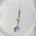 Süßer lila Erdbeere-Anhänger mit Perlen, Blumen und Sternen auf weißem Keramiktablett - Erdbeere / Lila