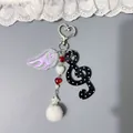 Niedlicher Schlüsselanhänger im koreanischen Stil mit Flügeln und Notensymbol auf Grau - Schwarz Rosa Punktmuster Note