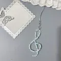 Blauer Notenschlüssel Anhänger aus Perlen für das Handy mit Sternclip auf grauem Grund - Lanyard-Stil