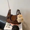 Dark brown suede underarm bag with puppy charm and gold hardware on book - Brown with Pendant