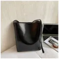 Sac seau en cuir noir brillant avec bandoulière pour un style urbain chic - Noir