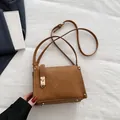 Bolso caja minimalista marrón en cuero mate con elegante cierre de hebilla dorada - Marrón