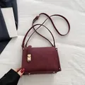 Sac bandoulière bordeaux chic avec fermoir doré tournant et texture daim élégante - Rouge