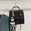 Dark brown suede backpack with white contrast stitching and cute dog charm accessory - Brown with Pendant