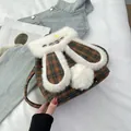 Detail of cute rabbit ear backpack with plaid pattern and white plush trim - Brown Grid