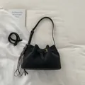 Schwarze Wildleder-Eimertasche mit goldener Schnalle und modischem Fransenanhänger - Schwarz