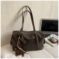 Schicke dunkelbraune Boston-Handtasche mit Hundeanhänger, gestylt für das Büro - Braun