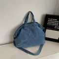 Blue washed denim canvas tote bag with adjustable shoulder strap and silver rivet details - Light Blue
