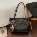 Detail of a black large-capacity tote bag featuring a cute bear pendant and shoulder straps - Black with Pendant
