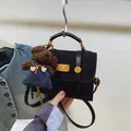 Matte black crossbody bag featuring a golden plaque and a cute brown plush bear charm - Black With Pendant