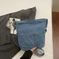 Hellblaue Jeansbeuteltasche mit Außentaschen und breitem Schultergurt im Vintage-Stil - Hellblau