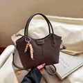Sac seau en cuir marron foncé avec texture verticale et breloque en perles colorées - Marron