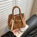 Brown matte suede handbag with V-quilting, decorative buckle, and beaded charm detail - Brown