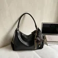 Minimalist black crescent shoulder bag in lychee leather with dachshund charm accessory - Black