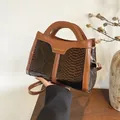 Detailed close-up of brown snakeskin texture handbag with gold Fashion & Bags lettering - Brown
