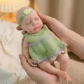 Lifelike 12-inch newborn baby doll in green knitted dress held by hands for gifting - Closed Eyes Green Knitted Dress Style