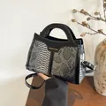 Detail of silver snakeskin texture and black patent leather on the crossbody handbag - Black