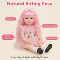 Lifelike 22-inch reborn baby doll in pink knit dress with long hair and floral embroidery - Pink / 55 cm