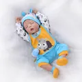 Lifelike sleeping reborn baby doll in blue and orange outfit on soft white plush rug - Blue / 56cm
