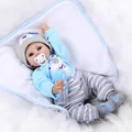 Realistic reborn baby doll in blue puppy outfit with bottle and pacifier on plush rug - 55 cm / Blue Puppy Style