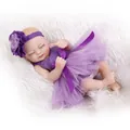 Realistic soft vinyl reborn baby doll in purple tutu dress on plush white background - Purple / 26cm
